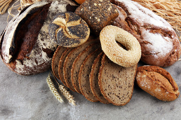 Different kinds of bread and bread rolls on board from above. Kitchen or bakery poster design