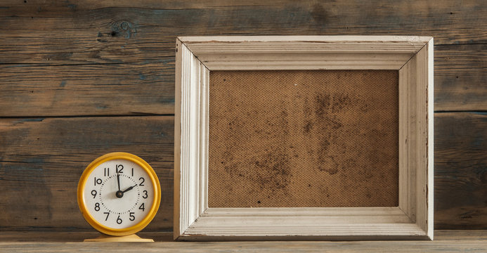 Wood Photo Frame And Clock On Wooden Table