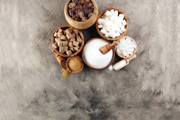 Various types of sugar, brown sugar and white on table