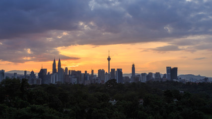 Fototapeta na wymiar Beautiful aerial view of Kuala Lumpur city skyline, skyscraper during sunrise with dramatic sky, clouds and sun rays.