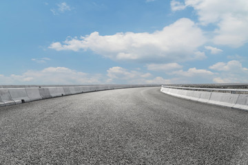 Asphalt pavements and square floor tiles under the blue sky and white clouds