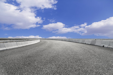 Asphalt pavements and square floor tiles under the blue sky and white clouds