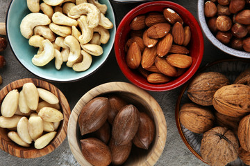 mixed nuts on grey background. Healthy food and snack. Walnut, pecan, almonds, hazelnuts and cashews.