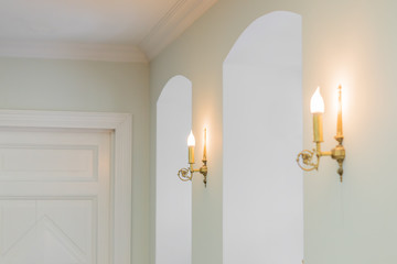 closeup of interior in classig style - wooden door, brass scones on wall