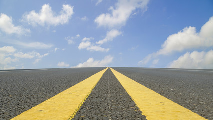 Asphalt pavements and square floor tiles under the blue sky and white clouds