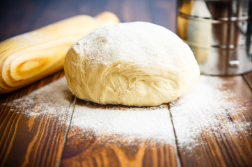 fresh raw dough with a rolling pin