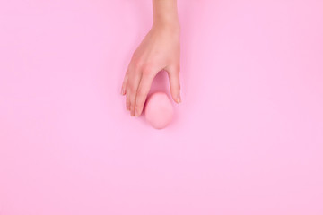 Happy Easter Day. Pink traditional easter egg with woman female girl hand on pink background