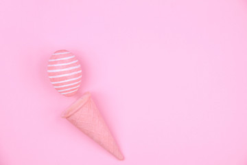 Happy Easter Day. Pink tradition easter egg with pink waffle cone on pink background