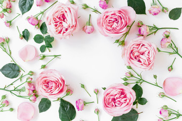 Flower frame with pink roses, buds and leaves on white background. Flat lay, top view. Spring frame background