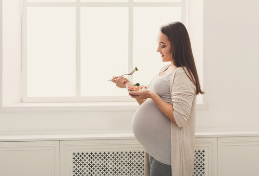 Young Pregnant Woman Eating Fresh Green Salad