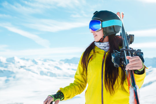Photo of sports girl looking sideways in helmet, mask with skis