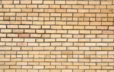 The texture of the old brick wall with concrete seams on a clear sunny day.