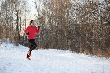 Photo of girl in sports uniform on morning run in winter forest