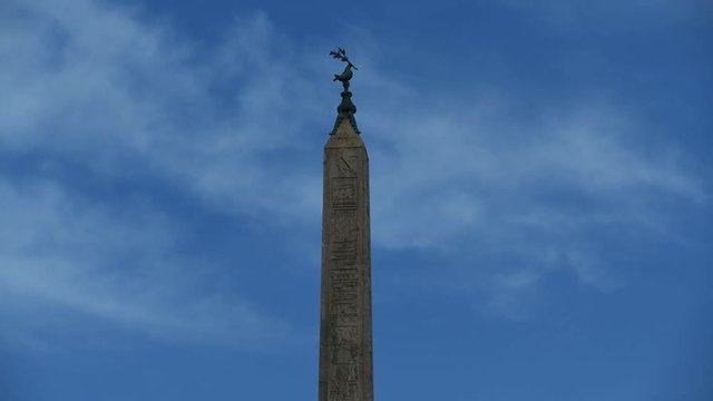 Ancient obelisk in Rome Navona's place, italian name obelisco agonale, time lapse against blue sky