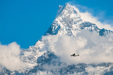 small airplane in front of  the himalayan mountains