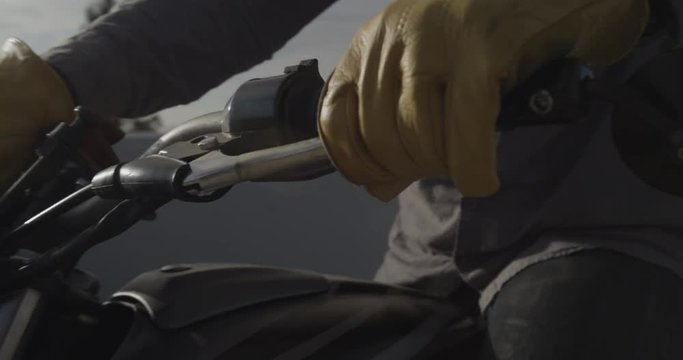 Close up, motorcyclist adjusts gloves before ride