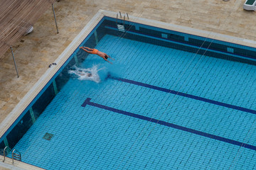 two people dive into the pool, view from the top