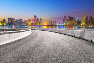 View of the skyline of Hangzhou urban architectural landscape from square floor tiles and empty asphalt pavement