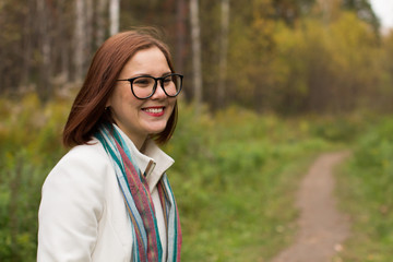 Fototapeta na wymiar Portrait of a young beautiful woman in an autumn park
