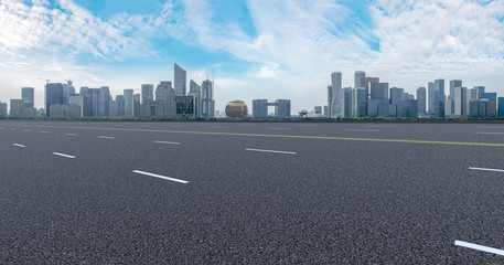 View of the skyline of Hangzhou urban architectural landscape from square floor tiles and empty asphalt pavement