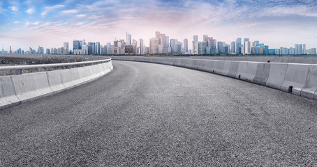 View of the skyline of Hangzhou urban architectural landscape from square floor tiles and empty asphalt pavement