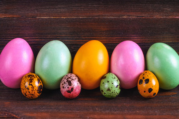 Multicolored easter eggs on a brown wooden table.