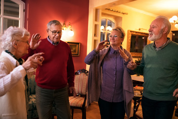 Group of old people smiling and dancing together