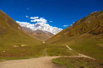 Colorful beautiful autumn landscape with snowy mountains in Svaneti. Georgia