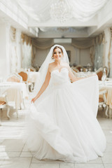 Fototapeta na wymiar Beautiful bride posing in wedding dress in fashion hotel