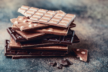 Chocolate bar pieces. Background with chocolate. Sweet food photo concept. The chunks of broken chocolate