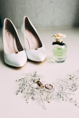 Gold rings of the newlyweds and bride's shoes
