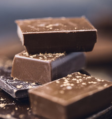 Chocolate bar pieces. Background with chocolate. Sweet food photo concept. The chunks of broken chocolate