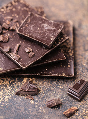Chocolate bar pieces. Background with chocolate. Sweet food photo concept. The chunks of broken chocolate