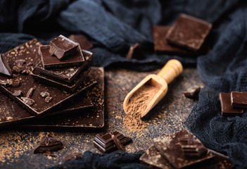 Chocolate bar pieces. Background with chocolate. Sweet food photo concept. The chunks of broken chocolate