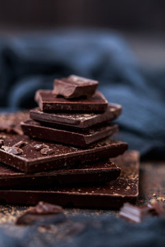 Chocolate bar pieces. Background with chocolate. Sweet food photo concept. The chunks of broken chocolate