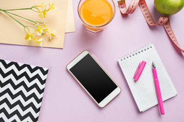 Top view of green apple, measuring tape, mobile phone, pen and open notebook. Fitness Concept.