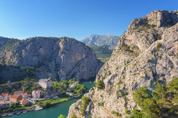Fototapeta na wymiar Omis town, canyon of the Cetina river and rocky Dinara mountains, top view from Mirabella (Peovica) fortress, mediterranean tourist resort in Dalmatia, Croatia