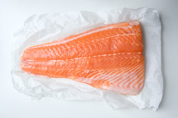 Fresh fillet of salmon fish on white paper closeup. Food photography