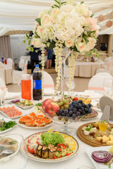 Table setting at luxury wedding reception. Beautiful flowers on wedding table. Number at table for guests on wedding banquet in restaurant hall