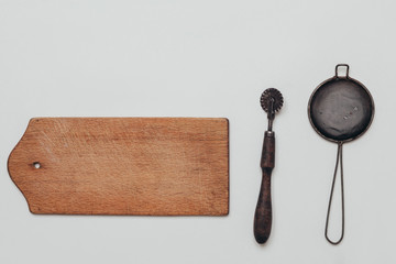 Vintage kitchen accessories like cutting board, strainer, pizza knife