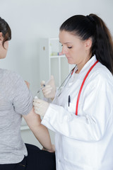 pediatrician giving an injection in arm
