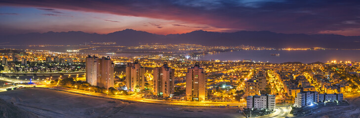 Obraz premium Panoramic aerial nocturnal scenic view on the Eilat (Israel) and Aqaba (Jordan) cities and northern shore of the Aqaba gulf, Red Sea 