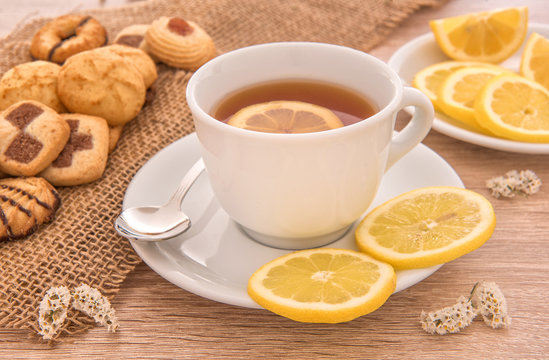 tazza di th&egrave; con fette di limone e pasticcini