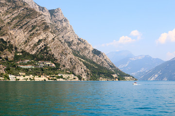 Lake Garda and mountain panorama with boat in Limone, Italy
