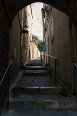 Fototapeta na wymiar Dark mediterranean staircase, alley in Antibes, Cote d'Azur