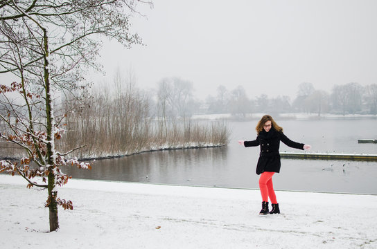 Fotografía de una chica jugando y dando un paseo por un parque nevado en Netherlands