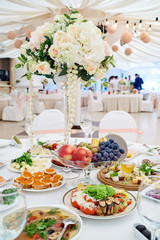 Table setting at luxury wedding reception. Beautiful flowers on wedding table. Number at table for guests on wedding banquet in restaurant hall