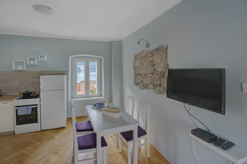 Interior of a living room and kitchen with view from the window to the sea in a private house