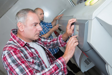 technicians checking a large inkjet printers