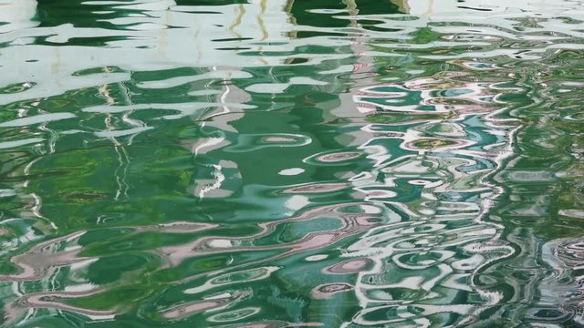 Skyscrapers reflecting at water surface, making abstract shapes; slow motion; Shekou fishing port, Shenzhen, China;